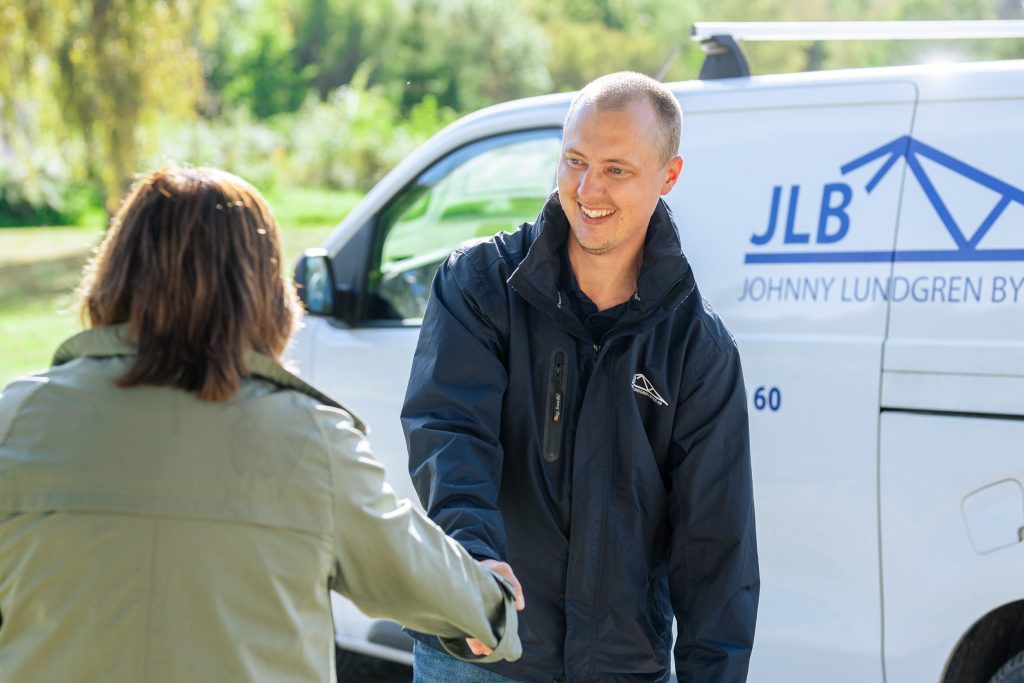 En certifierad fönsterbytare som skakar hand med en kund som köpt nya fönster